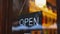 Close up view of an Open sign hanging on the glass door of a Japanese sake bar