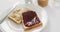 Close up view of peanut butter and jelly sandwich in a plate on white surface