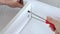 Close up view of a person assembling new white drawer using a screwdriver