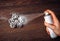 Close up view of person hand using metal canned spray snow to spray decorate Christmas decoration pine cones in winter  art.