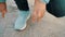 Close-up view of person tying shoelaces on blue sneakers