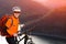 Close-up view photo of mountain cyclist while stands under the river against beautiful landscape.