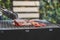 Close up view of pieces of sliced beef on charcoal grill at Outdoor party. Human`s hands using meat tongs to grill Multiple slice