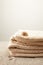 close up view of pile of towels with seashell on sand on grey backdrop