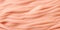 A close up view of a pink blanket, on peach fuzz background.