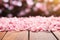 Close-up view of pink cherry blossom flower petal on wood table top in Spring.
