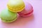 Close up view of pink, yellow and green macaroons french traditional cookies made of almond flour.