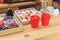 close-up view of plastic cups and various pastries on wooden counter