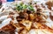 Close-up view of a plate of shaved pieces of kebab meat and bread chunks