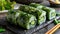 A close-up view of a plate of sushi rolls topped with avocado and cucumber, set against a black background