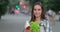 Close up view of pretty girl turning head and looking to camera while holding bag with food. Smiling woman posing to