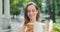 Close up view of pretty millennial woman browsing net while carrying paper bag with groceries. Charming young girl using