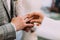 The close-up view of the priest putting the wedding ring on the finger of the groom.