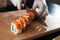 Close-up view of process of preparing rolling sushi. making the sushi with sauce and sesame seeds, pours delicious fresh