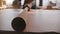 Close-up view of professional artisan businessman opening and spreading a big roll of leather on large workshop table.