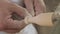 Close up view - professional man carpenter using chisel for shaping piece of wood on wood turning lathe at workshop