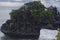 Close up view of Pura Batu Bolong on top a cliff in Tanah Lot, Bali. Uneven horizontal line and tigh composition due to get a nice