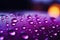 Close up view of raindrops on a window, kissed by purple light