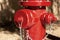 Close up view of red fire hydrant with shaded areas in background