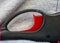 Close up view of red igniter button on black automatic lighter.  Abstract curves and design