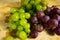 Close up view of a red and yellow muscat colored grape on a wooden board