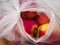 Close-up view of ripe red apples, source of vitamins, packed in a transparent plastic bag, environmental pollutant, handles tied