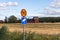 Close up view of road signs on yellow field and blue sky with white couds backgrounds.