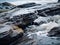 a close up view of a rocky shoreline with water flowing over it