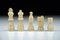 Close-up view of a row of white chess pieces on a black-white blurred background