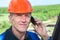 Close-up view of senior manual worker in orange hardhat calling on phone