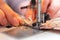 A close-up view of sewing process, hand of old woman using sewing machine, selective focus technique