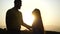 Close-up view of silhouette of young european couple in love enjoying romantic evening in field against backdrop of