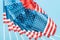 Close up view of silk american flags on sticks on blue background.