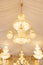 Close up view of single hanging luxury chandelier with white curtains ceiling