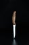 Close-up view of single kitchen knife for meat on black. Kitchen knife balanced on its end