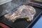 Close up view of a Sirloin cut steak, being grilled on a grilling pan