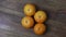 Close up view of slowly rotating ripe orange mandarins fruit isolation on wood background