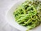 Close up view of spaghetti cooked with a green homemade sauce