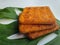 Close up view of a stack of crackers biscuit on an ornamental green monstera leaf.