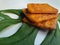 Close up view of a stack of crackers biscuit on an ornamental green monstera leaf.