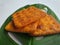 Close up view of a stack of crackers biscuit on an ornamental green monstera leaf.