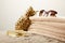 close up view of stack of towels, sunglasses, tanning oil and golden decorative pineapple on sand on grey backdrop