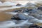 Close up view of a stony riverbed and silver stream