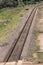 A close up view of a straight metal and concrete railway lines that is curving at the end