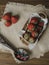 Close-up view of strawberries in wicker bowl on table. Mellow strawberries in basket on tablecloth with wooden painted spoon