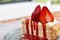 Close-up view, Strawberry cheesecake with strawberry slices on a gray ceramic plate.