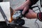 Close-up view strong man master without gloves on arms, performs metal cutting with an angle grinder in the garage workshop, blue