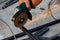 Close-up view strong man master without gloves on arms, performs metal cutting with an angle grinder in the garage workshop, blue