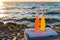 close-up view of summer drinks with straws and cooler on sandy beach