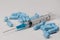 Close up view of a syringe with hypodermic needle and generic blue pills